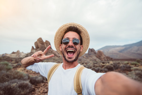 Handsome hiker taking a selfie hiking a mountain using his smartphone