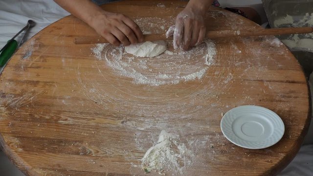 woman who makes "bazlama",  "G&ouml;zleme" and "yufka". raw dough opens with rolling pin. traditional Turkish breakfast and snack meal.