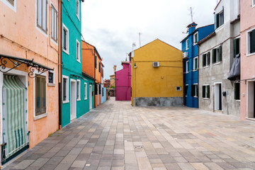 Fototapeta na wymiar Burano, Venice, Italy - May 21, 2019: Colorful painted residential houses in Burano island, Venice, Italy. Burano street with ?olorful facade building. Colorful architecture in Burano island.