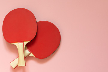 Red tennis ping pong rackets isolated on a pink background, sport equipment for table tennis