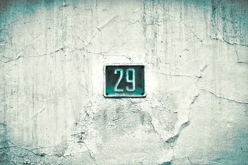 Number 29, twenty-nine, blue plate on a grungy white surface, split toned and slight vignette effect added.