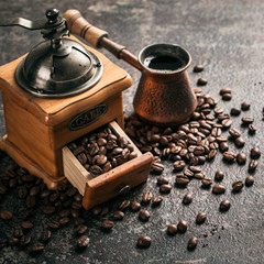 Coffee with coffee grinder and coffee beans on dark textured background. - obrazy, fototapety, plakaty