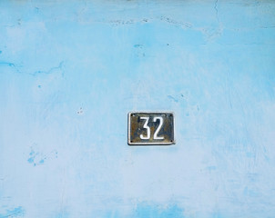 Number 32, thirty-two, on pale white and blue aged surface.