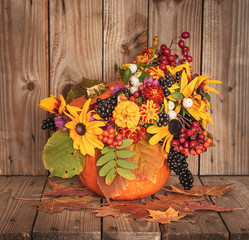 Autumn bouquet in a vase made out of pumpkin for Thanksgiving Day.
