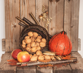 Thanksgiving Day decoration with pumpkin, apples  and basket of walnuts. Rustic decoration.