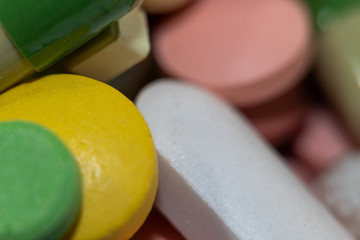 yellow and green tablets. selective focus, blurry different tablets and capsules as background.