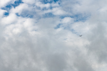 Airplane Flying through Blue Sky with Clouds
