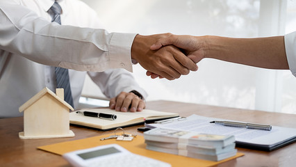 Real estate agent shaking hands with customer for deal contract to buy house, insurance or loan real estate