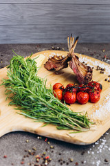 Meat ribs with vegetables on a wooden Board with herbs.