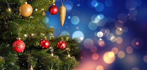 Near December, in the winter time, the Christmas tree has a green pine tree decorated gift with presents and the background texture is blue bokeh.