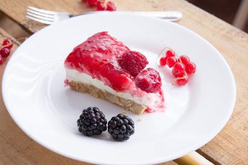 Cheesecake com calda de frutas vermelhas no prato branco 