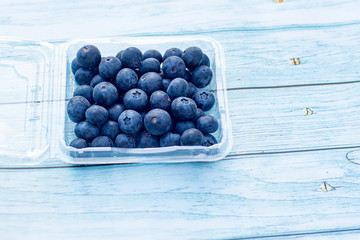 A tray of delicious fresh superfood blueberries on a wooden background