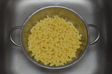 boiled yellow pasta in a colander