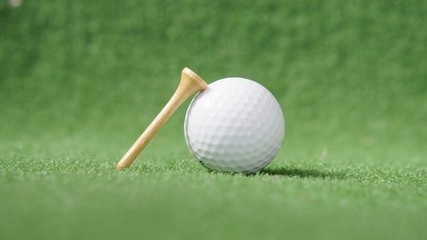golf ball and tee on green grass