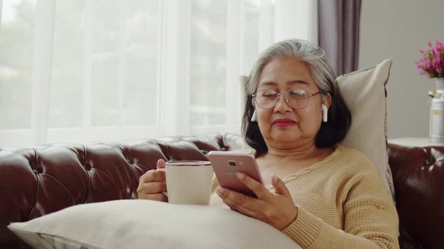 Senior woman listening music with happiness at home