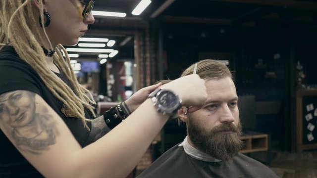 Young handsome bearded man at barbershop