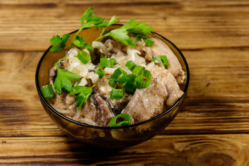 Marinated carp in glass bowl on wooden table