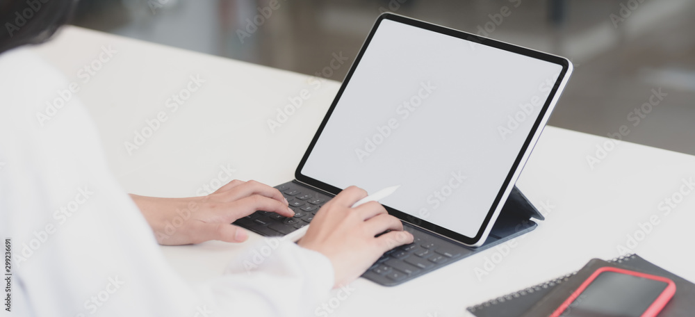 Wall mural cropped shot of young businesswoman working on her project while typing on tablet