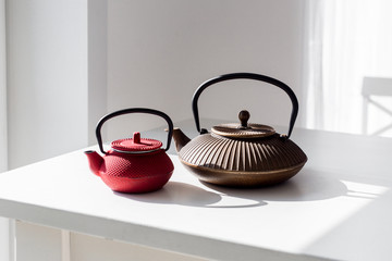 two chinese teapots standing on white table