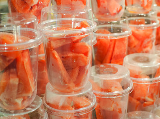 Pieces of fresh watermelon placed in plastic glasses ready for blender. Fruits drink Smoothies frosty. Healthy food.