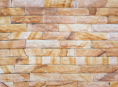 Beautiful brown rough stone wall textured and background. Pattern of stone building facade. Decorative brown textured tile. 