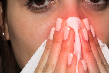 Young girl with cold, flu, allergy blowing nose