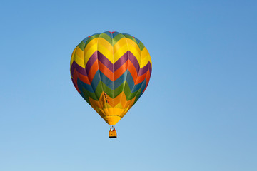 Flying hot air balloon in blue sky, summer adventure