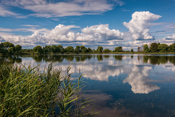 Fototapeta na wymiar Reflection of clouds in sunny weather in a lake. Russian shrines. Joseph-Volotsky Monastery in Teryaev. Moscow region, Teryaevo.