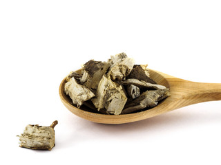 Dried sunflower roots lie in a wooden spoon on a white background