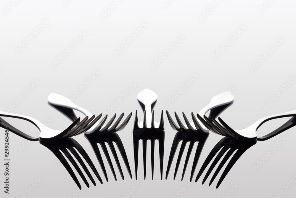 Wall mural light and shadow of forks on white background