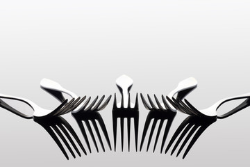 light and shadow of forks on white background