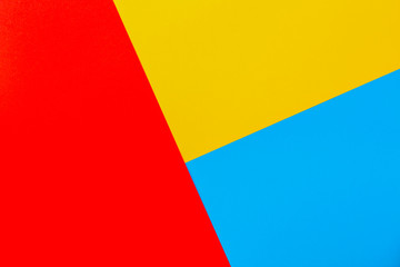 Color papers geometry flat composition background with yellow red and blue tones