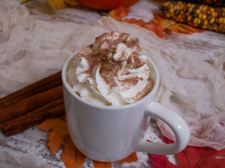 Looking down at white cup of hot chocolate with whipped cream and chocolate sprinkles