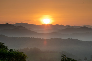 Morning mist covered on hill after sunrise at tropical forest. Thailand