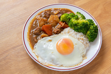 Chicken curry Rice on wooden background ( Poached egg, Potato, enoki mushroom, onion, broccoli, Japanese style,)