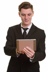Young handsome blonde businessman in suit using digital tablet