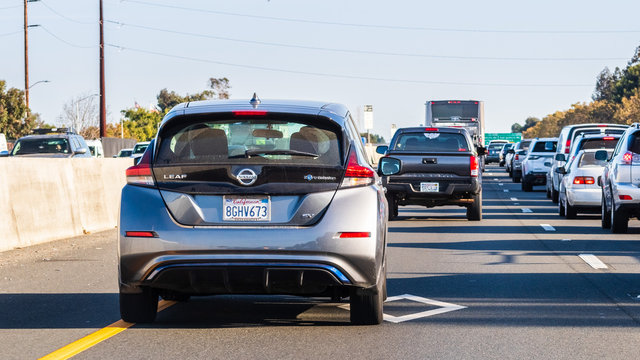 Oct 24, 2019 Mountain View / CA / USA - Back view of the new Nissan Leaf driving on the carpool lane on a busy freeway in Silicon Valley, South San Francisco Bay Area
