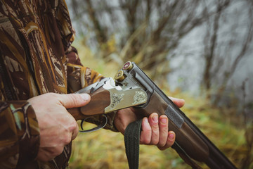 Russia, Kholmogory-October 17 2019 hunter loads a rifle in the autumn forest.