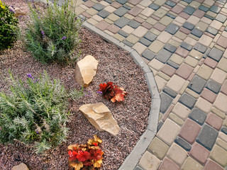 Nested pavers of various colors, around the grass is green, chic garden