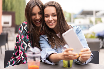 Close up lifestyle selfie portrait of pretty fresh young brunette best friends girls making selfie, having fun