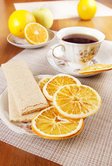 Tea with fruit chips made of oranges and crispbreads. Healthy vegetarian dietary breakfast