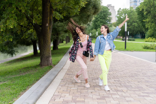 Two cheerful young girls walking in the Park