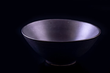 Black ceramic bowl on black background