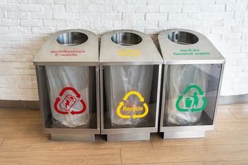 three modern waste bins Silver color for e-waste, recycle, general waste with red, yellow and green symbols