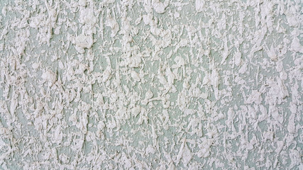 the facade of the wall is light blue and white convex spray on it from the emulsion mixture