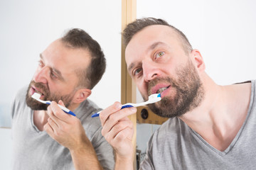 Fototapeta premium Man brushing his teeth in bathroom