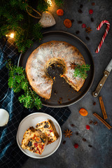 Christmas Pudding, Fruit Cake decorated with sugar powder and spruce twigs on grey table, copy space for text. Homemade traditional Christmas festive dessert. Top view