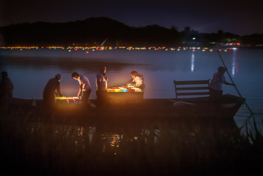 People on boat preparing for lantern floating ceremony in Hirosawa pond in Kyoto, Japan