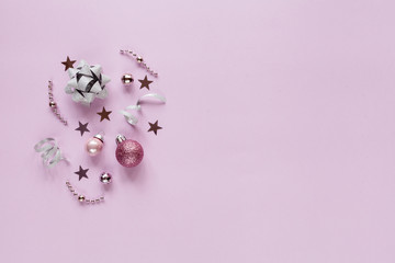 Pink background with christmas decor: balls, stars, festive. Flat lay.