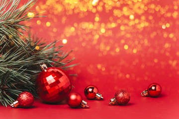 Christmas red background with christmas balls and present with candies and snow falling on them.
